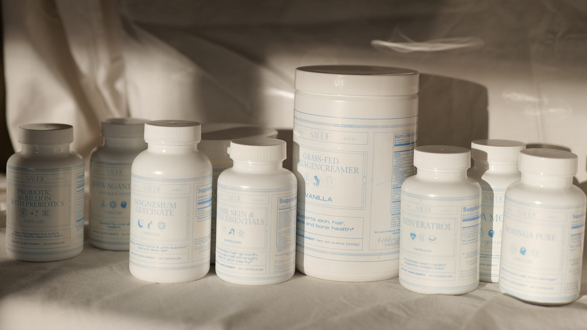 White cylindrical supplement containers with labels on a draped fabric background